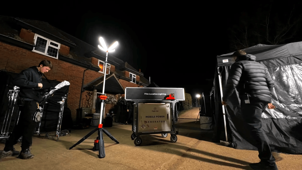 Film set with lighting equipment outdoors.