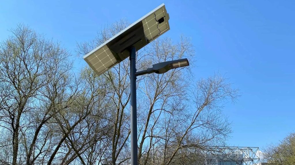 Solar Street Lighting Solar-powered street lights in South America public park at dusk Modern solar street lights installed in a public municipal square with people walking at dusk